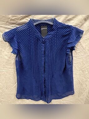 Covington blue polka dot button up blouse with ruffles.